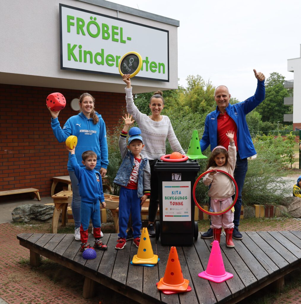 v.l.n.r. Trainerin Alicia Schwarz, Kitaleitung Ulrike Jäger und Jens-Uwe Kunze mit Kindern der Kita Daumstraße